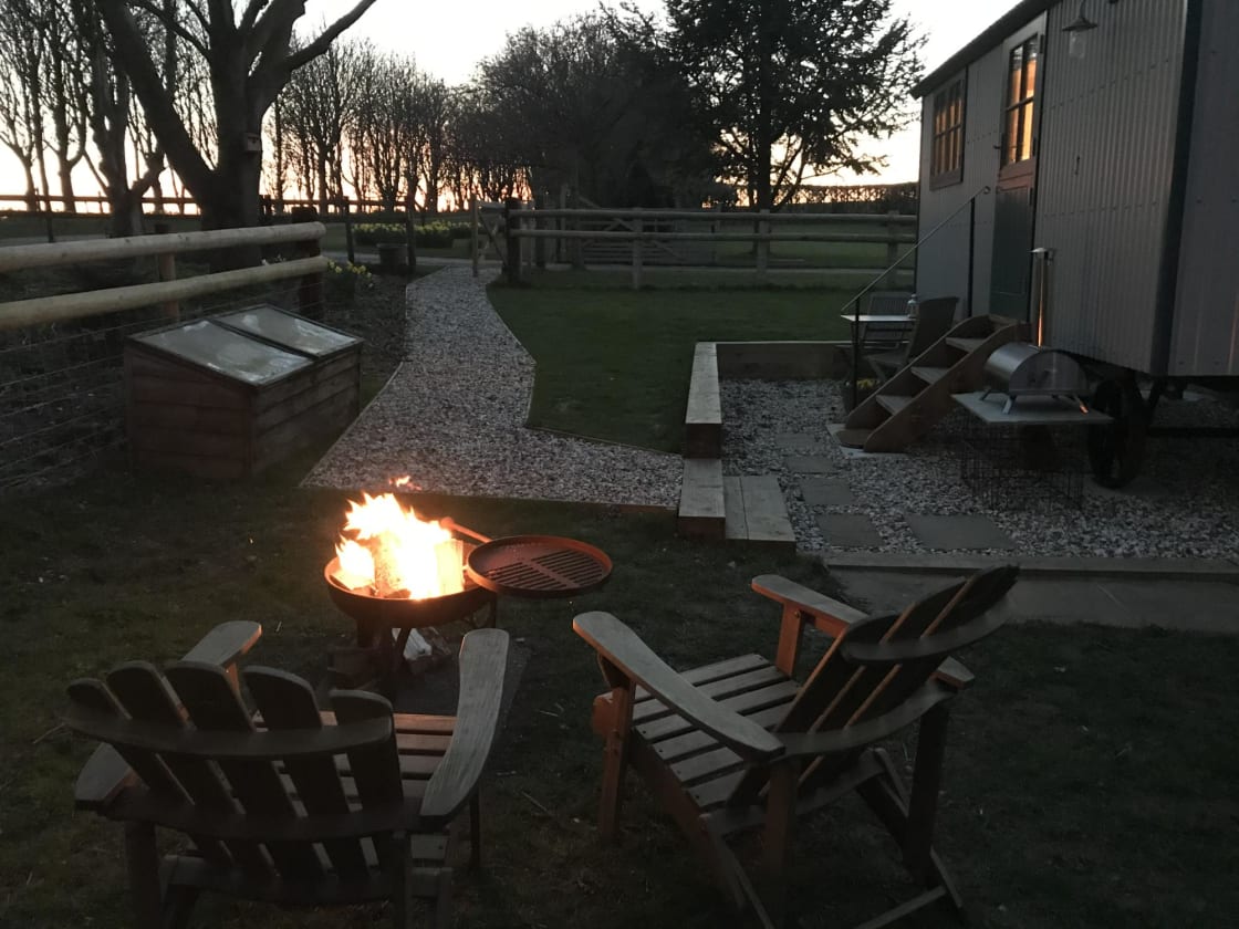 The glowing firepit/BBQ with the Pizza oven in the background