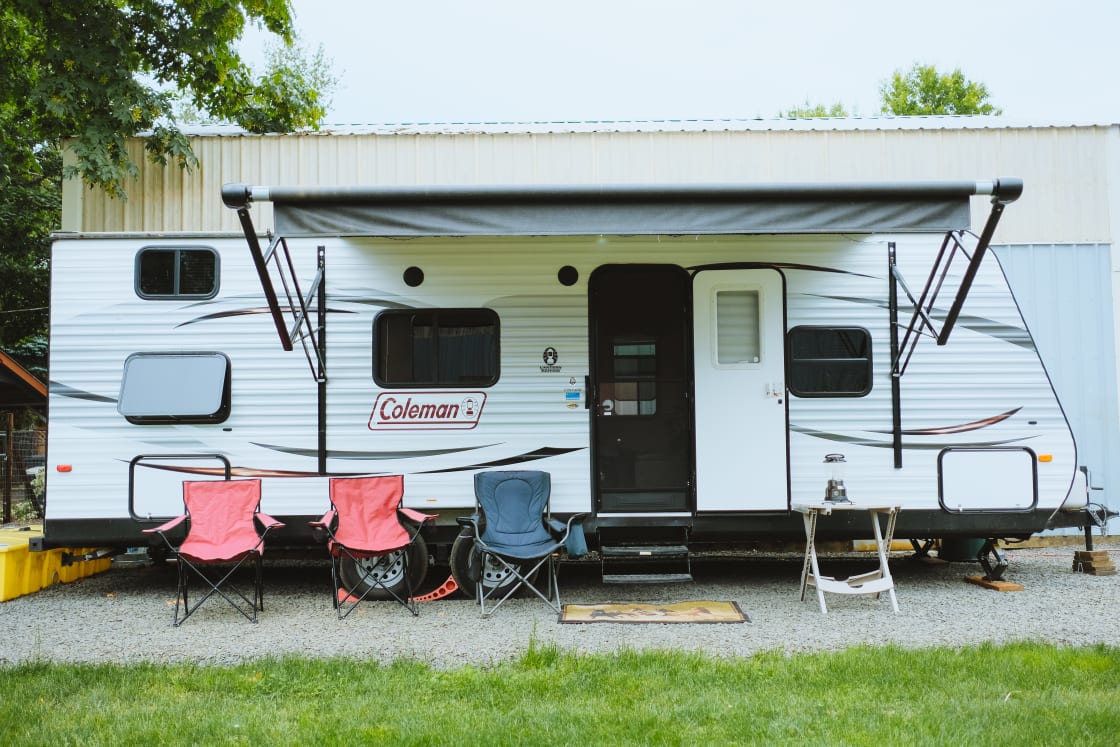 The exterior of the camper. Complete with chairs for friends and an awning to enjoy any kind of weather. 