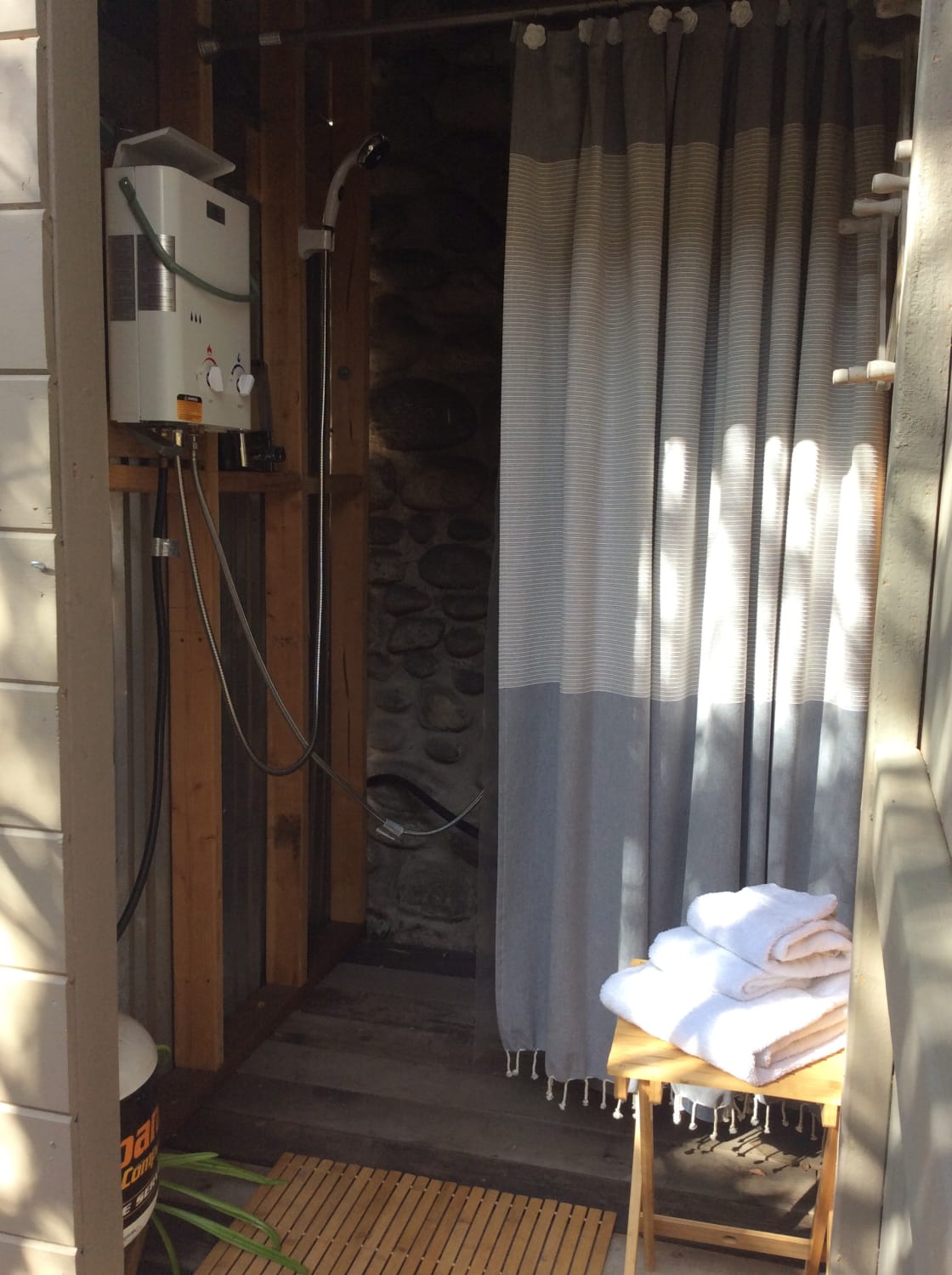 Outdoor, but enclosed, shower area with portable water-heating tank. This area is less than 10 feet from the tent.