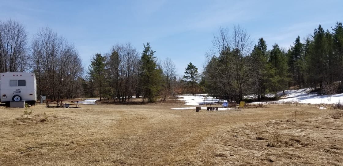 View from west end of property. Fire ring area and camper area visible. Plenty of space to run! Also for extra parking for the boat and toys!