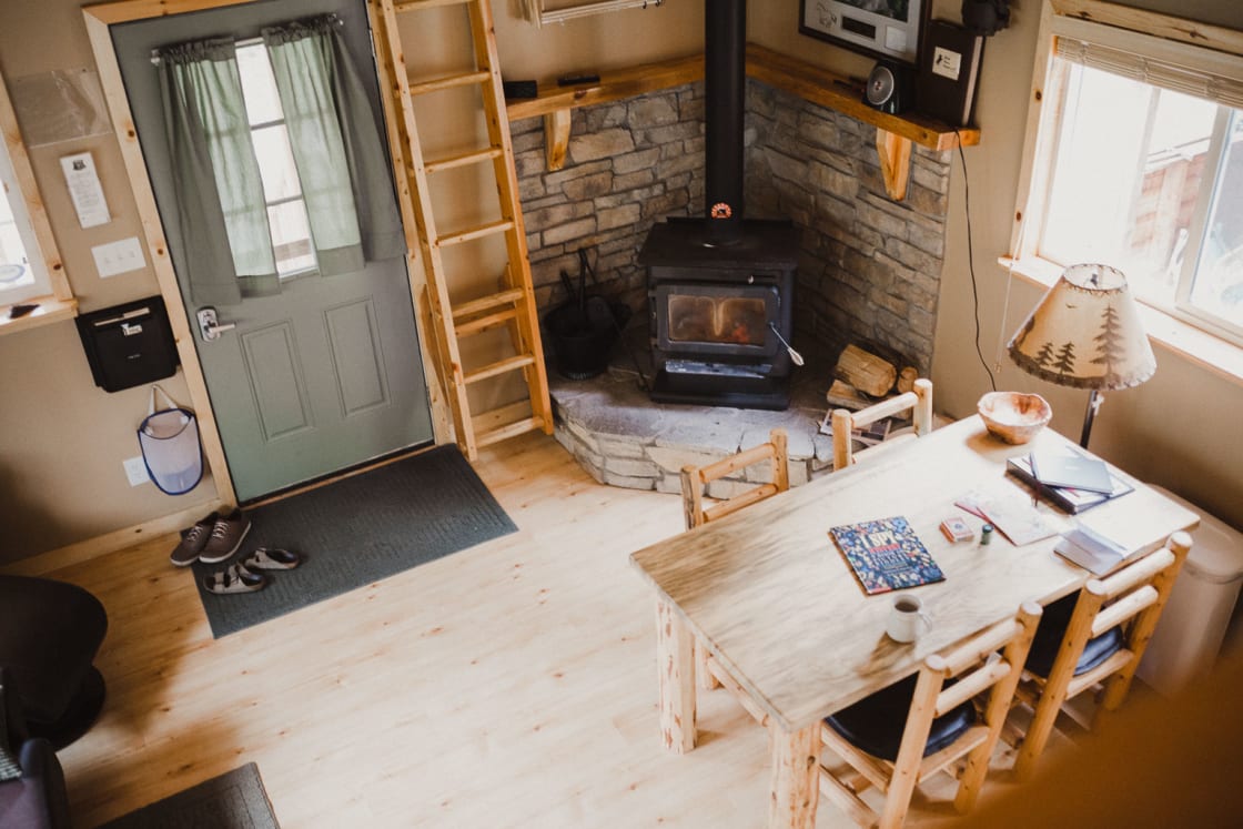The interior of the main cabin is fully equipped with a wood fire place, kitchen table, fold out couch, and kitchen. 