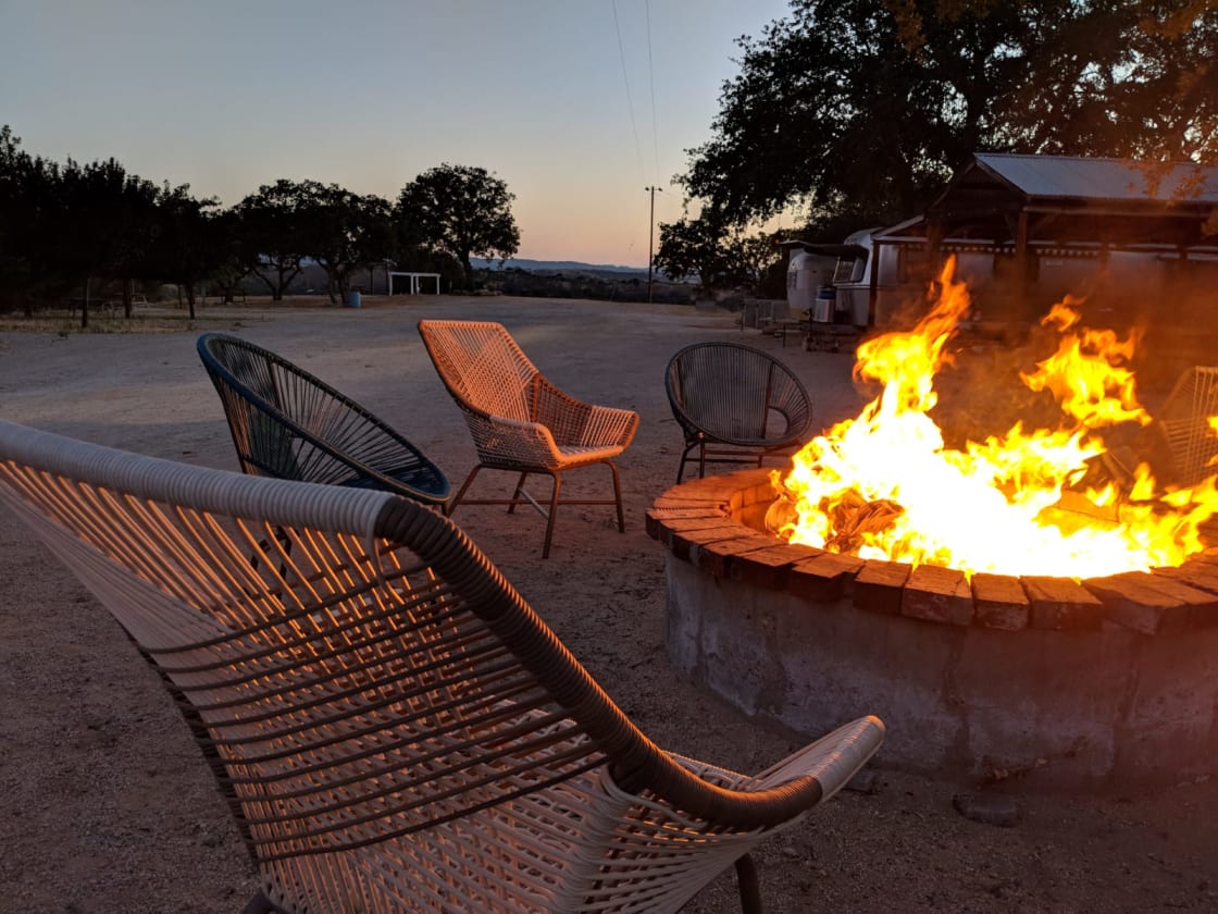Large fire pit with comfy chairs.  Not pictured there is an outdoor covered kitchen, BBQ grill, and dinner table for 50+