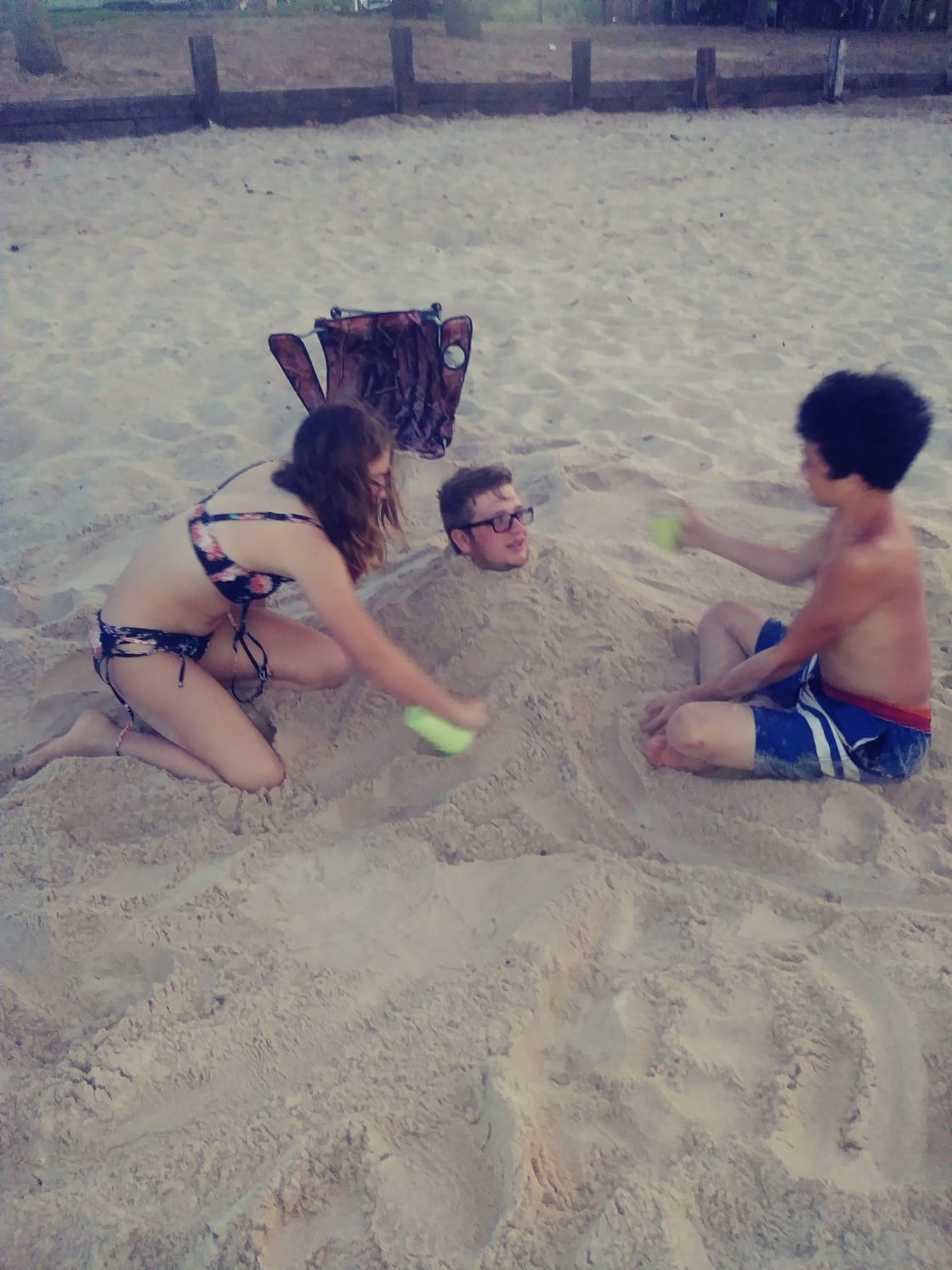 The best part about sand is getting to bury your big brother