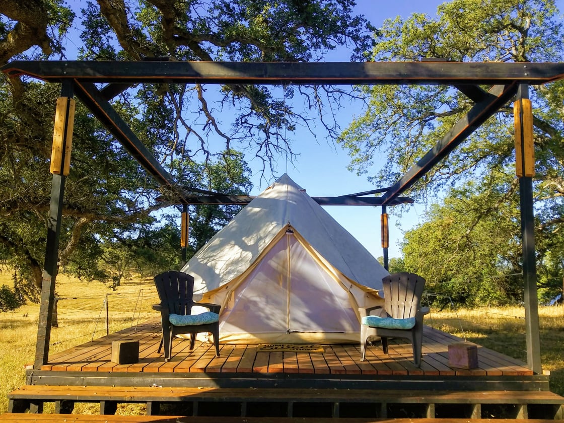 12ft x 12ft Yurt style canvas tent propped up on a cedar wood deck