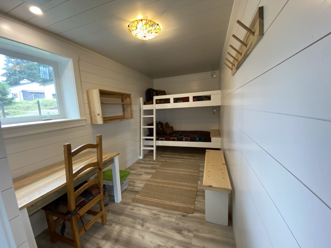 4 Semi-private bunk-style rooms.  Hand-made desk and chair with wall shelves and hooks and a sitting bench.