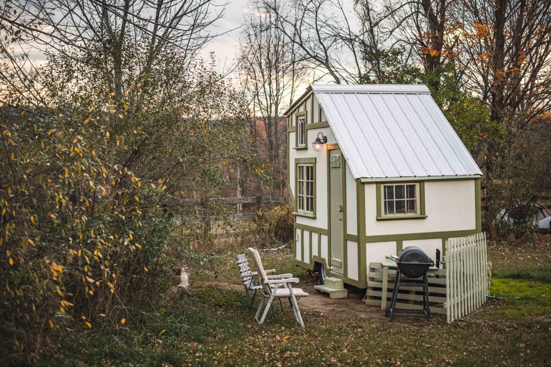The tiny house has it's own private courtyard with a grill and chairs