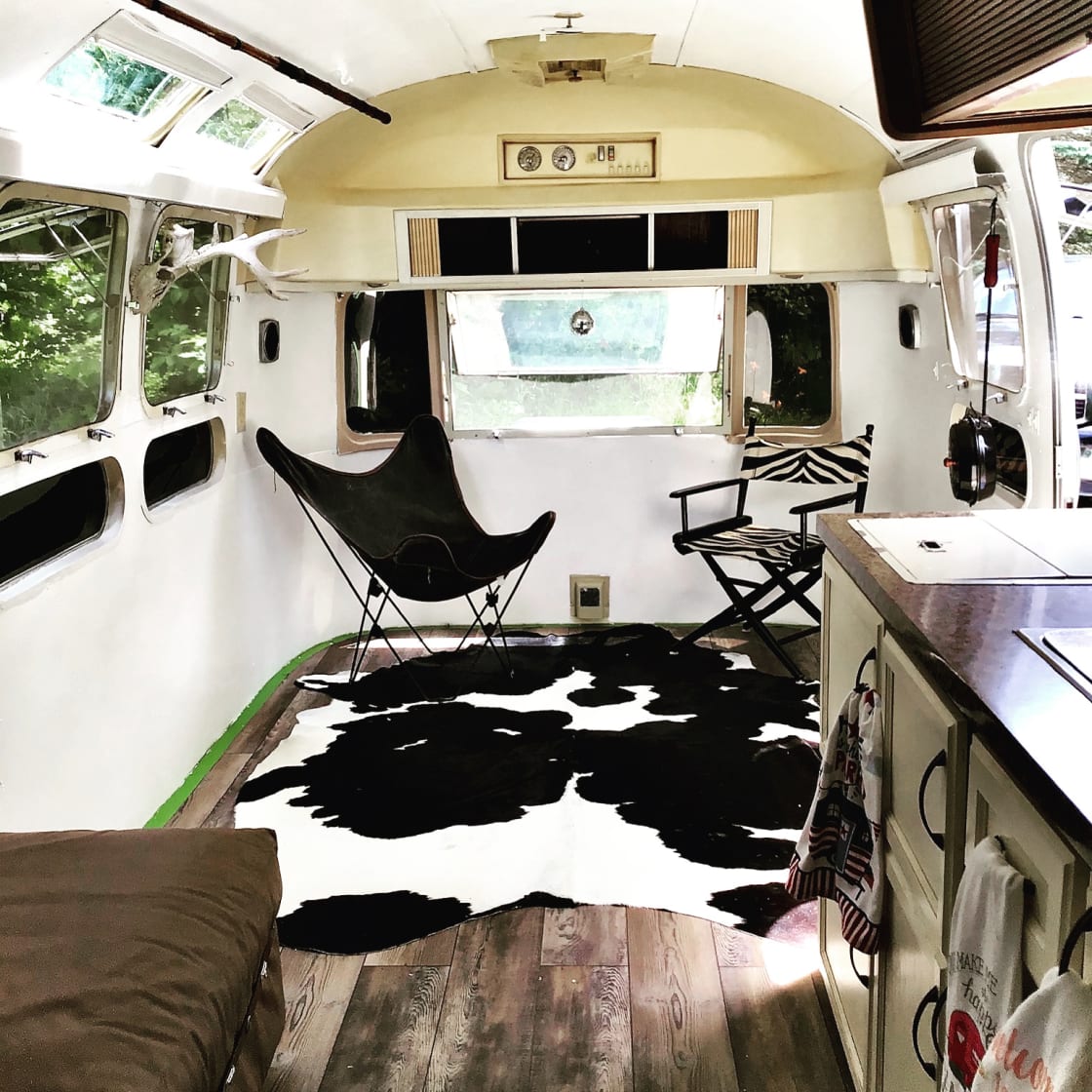 This is what the airstream looks like inside now I have two twin beds and then I bring in the blowup air mattress it's a double that you can put right down there where the chairs are and I have a grill, coolers, coffee pot, toaster, utensils!