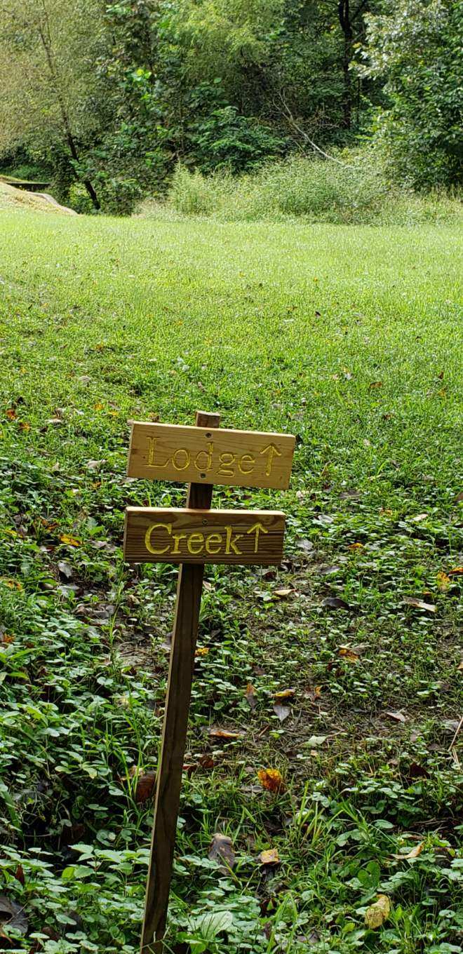 Signs directing you to creek, cabin, lodge, trail, bethel, playground, and pool.