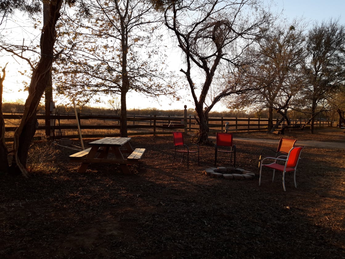 Picnic table and fire pit, bbq grill and a few chairs.