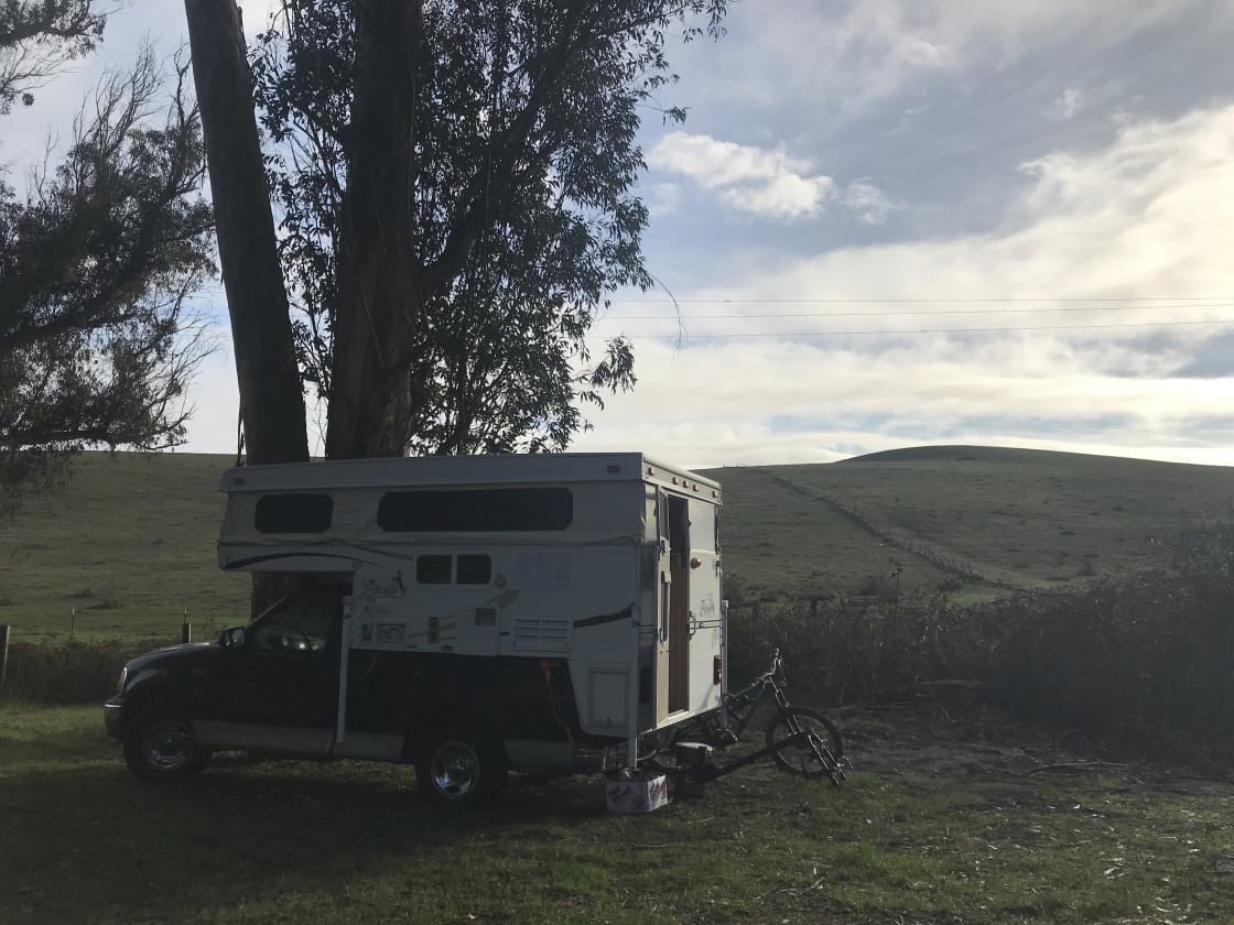 Flat-enough ground and space for a truck camper or a van. Not recommended for a full-on RV.