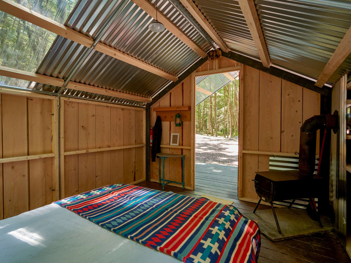 This is a small off-grid cabin/tent built with trees from our property. The inside structure has a full sized bed. Please note we no longer have the wood burning stove due to town regulations. 