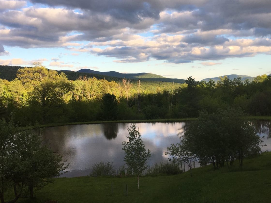 The way the clouds and sun dance across the mountains and ridges here adds drama to already amazing views. Campsite(s) are tucked down in the meadows and forests beyond this large pond, where the evening sun hits.