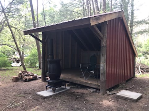 Adirondack shelter with wood burning pot belly stove.