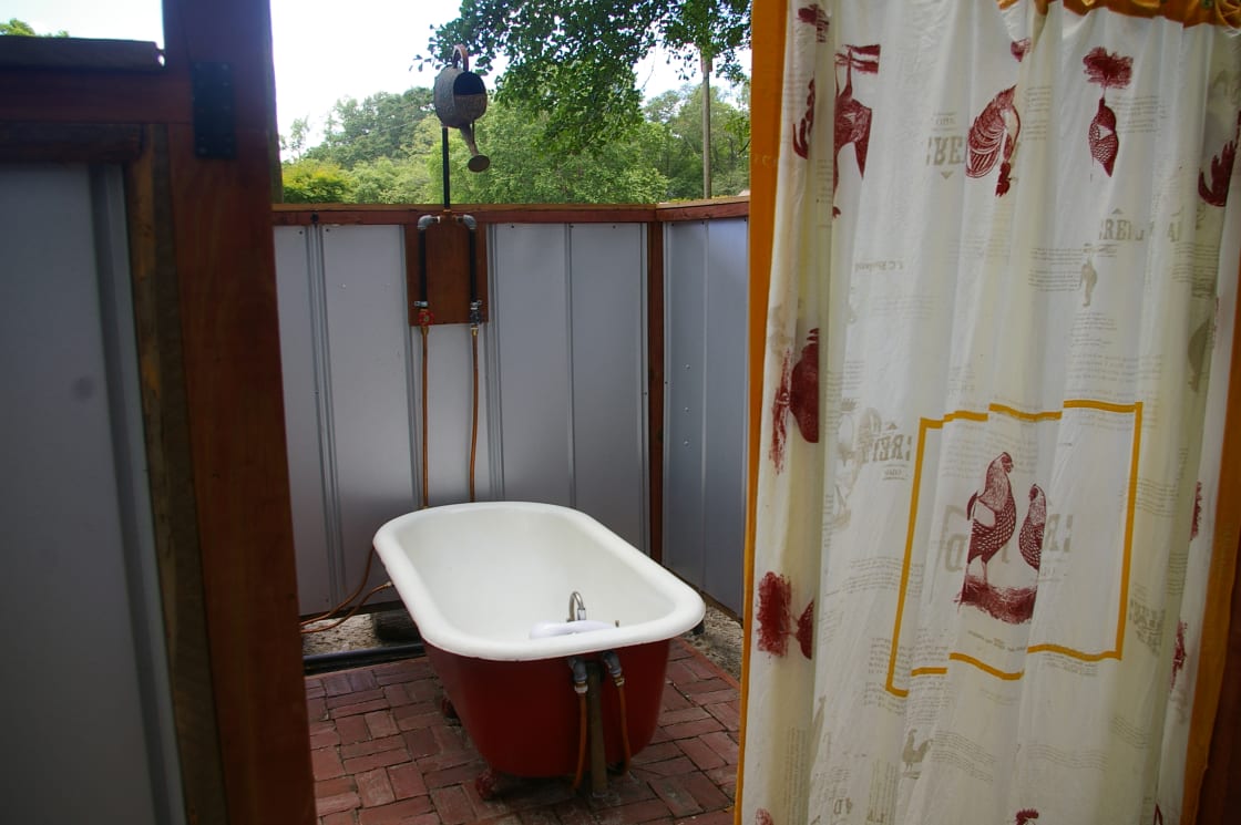 Outdoor cast iron tub with overhead shower or hand held sprayer. Hot shower or bath so refreshing.