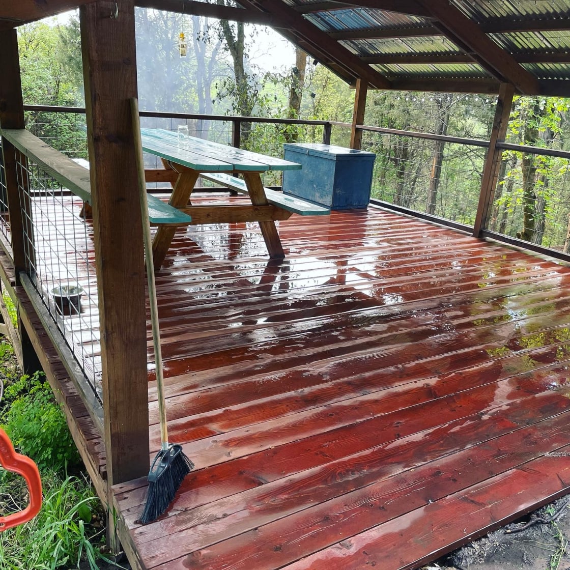 Freshly washed floor with our large picnic table. The blue box has 8 camping chairs, 1 large tent and 4 cots available to rent.