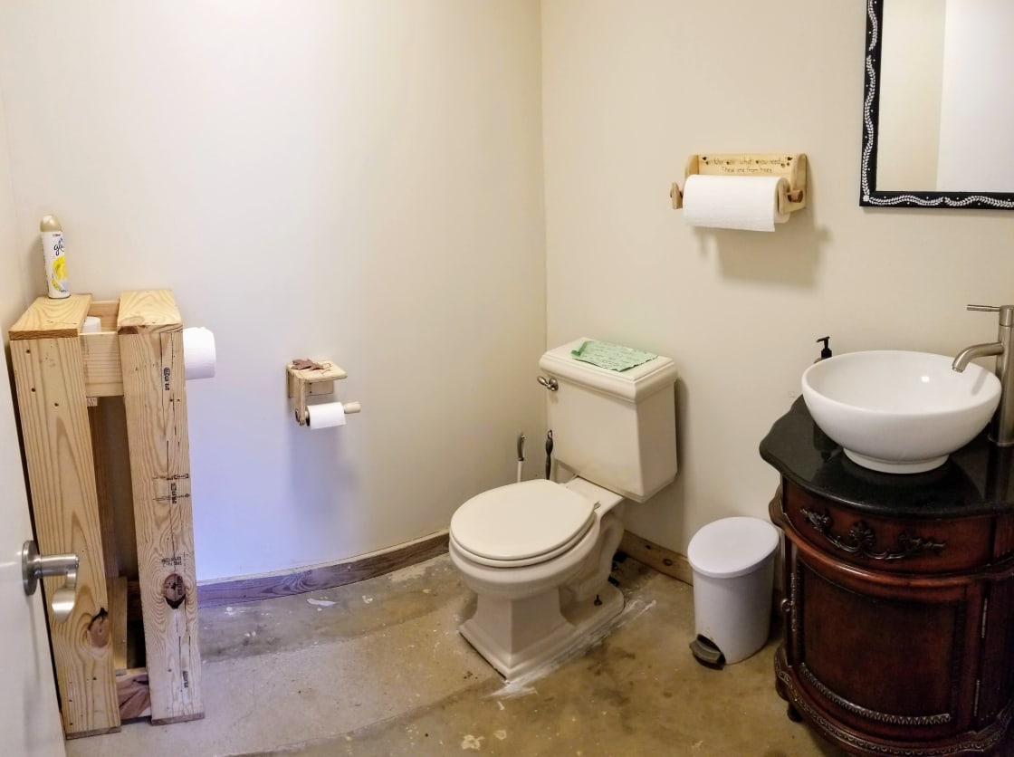 Interior bathroom with a toilet and sinks.