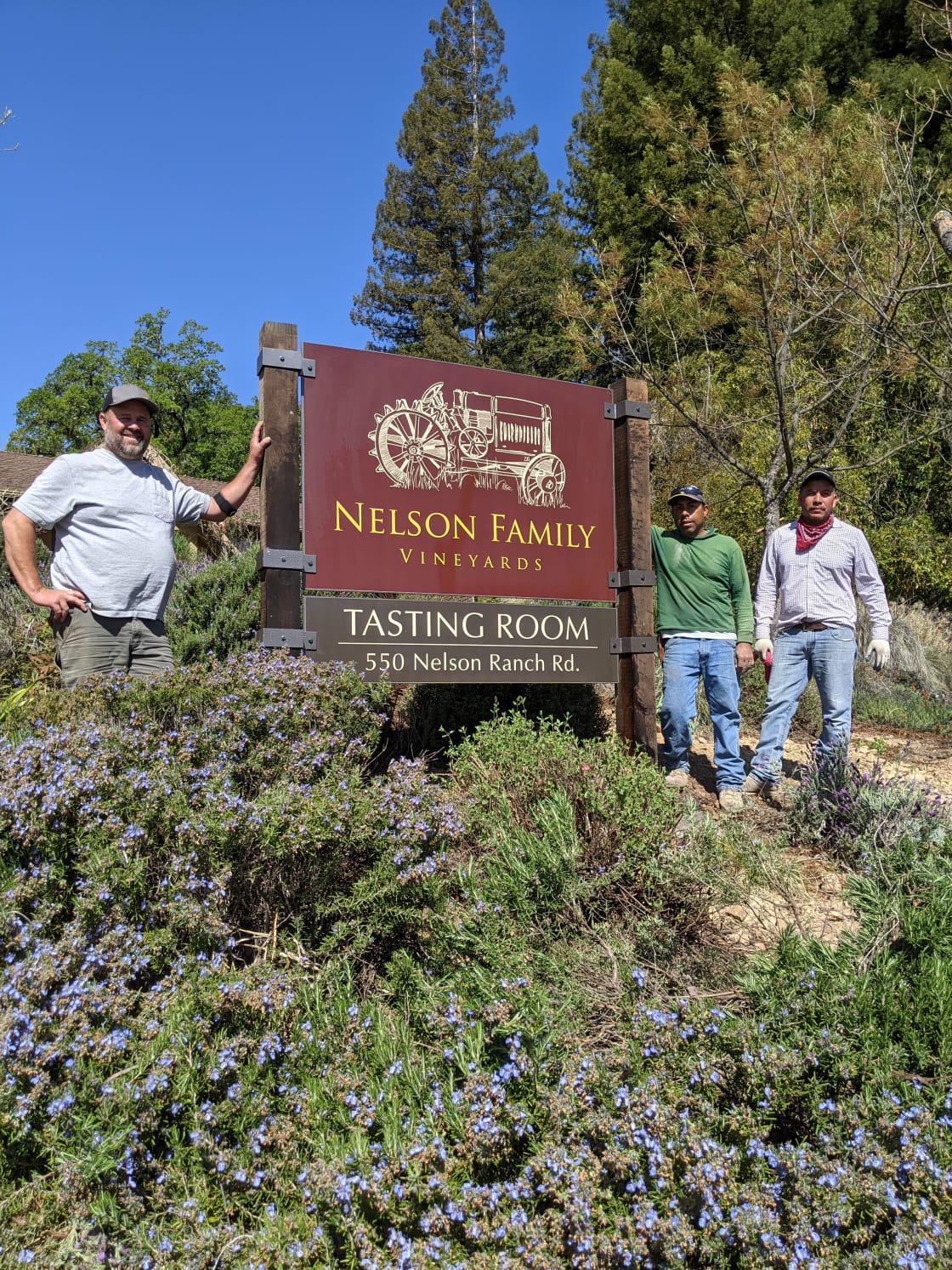 Tyler Nelson and crew by tasting room sign