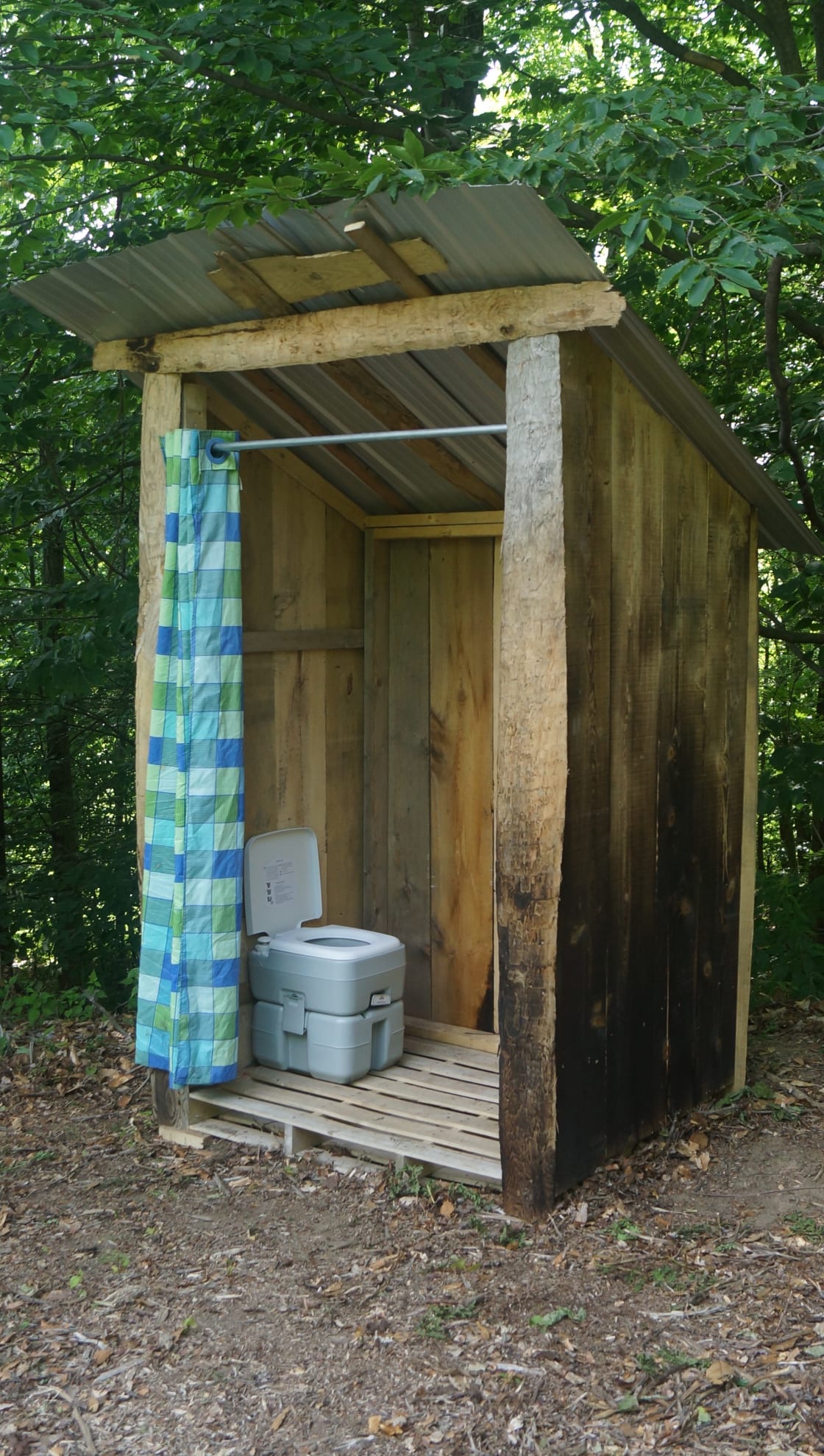 Portable toilet in outhouse