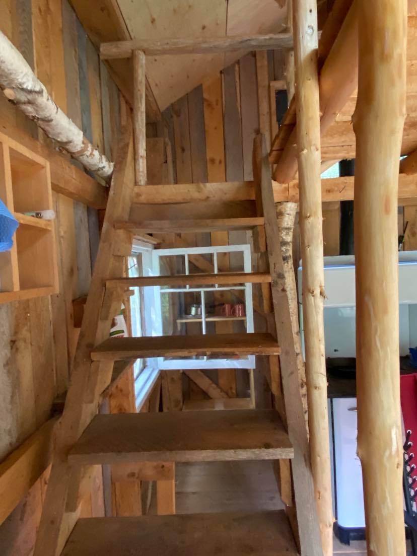 Wood stairs up to the sleeping loft above.