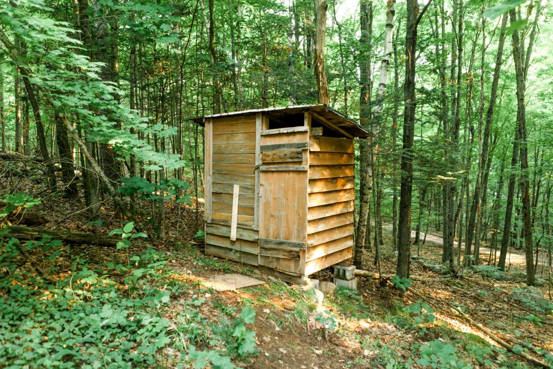 Rustic charm outhouse on site.