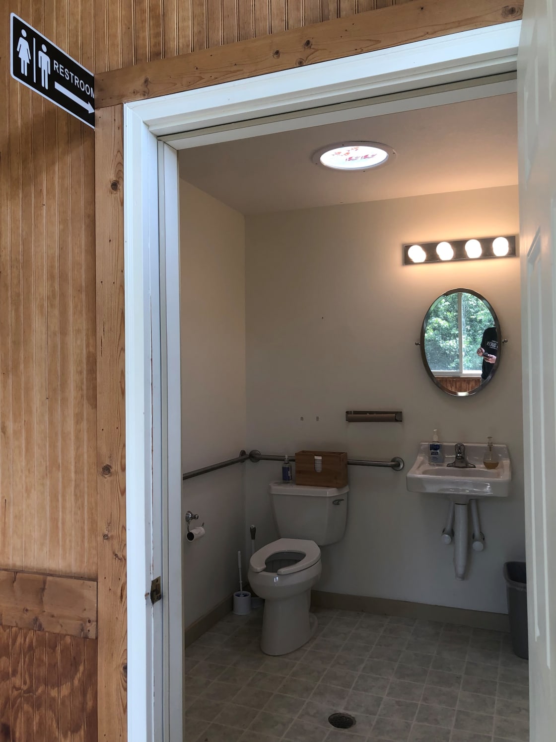 The bathroom is located at the back of the porch at the lodge.