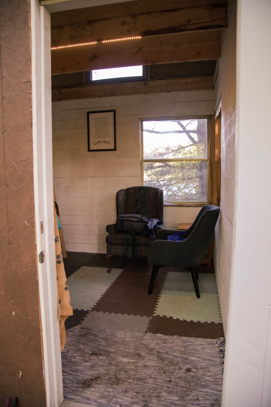 The bunkie entrance, the main level has two chairs, a desk, some small hooks for coats and keys and a padded floor.