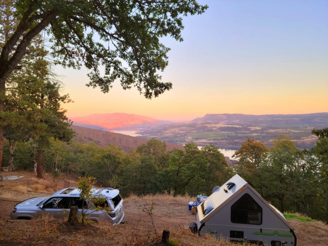 The view was beautiful. On the other side of the camper is the picnic table, water hose, and electrical cord.  To the right of our camper just a few feet was a flat area that our friends placed their tent on. 