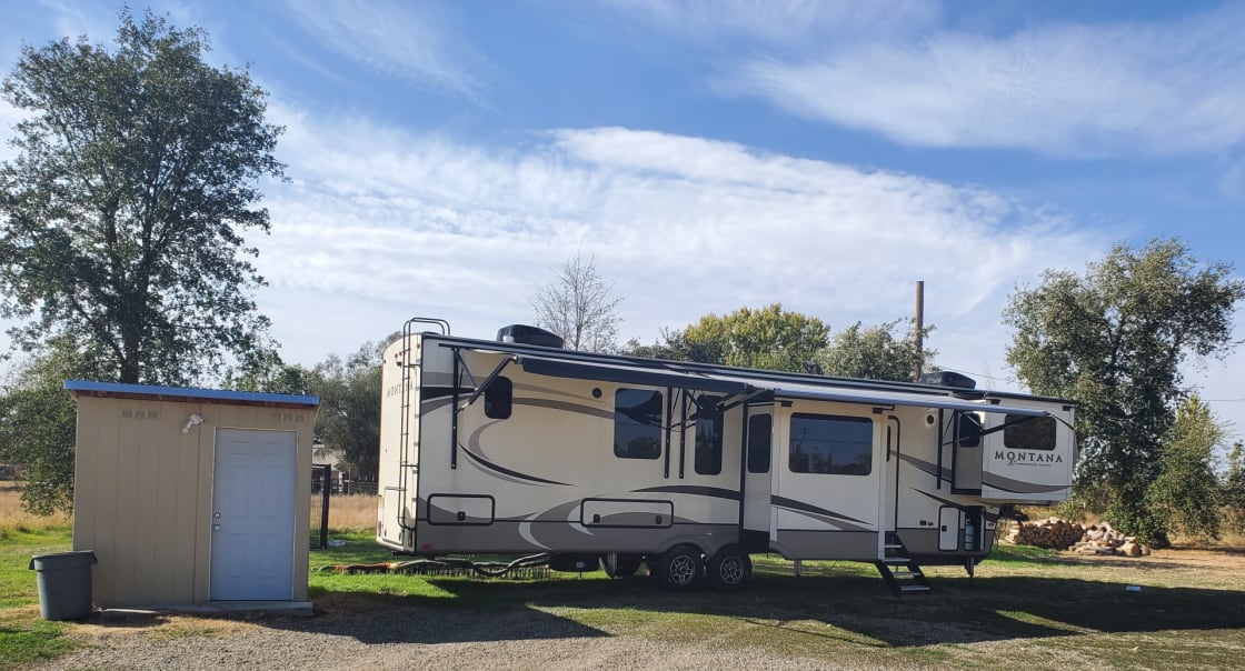 This is our site with RV hook ups. This 42 foot trailer fits nicely. Plenty of shade with a washer and dryer in the little shed. Also a dog kennel.