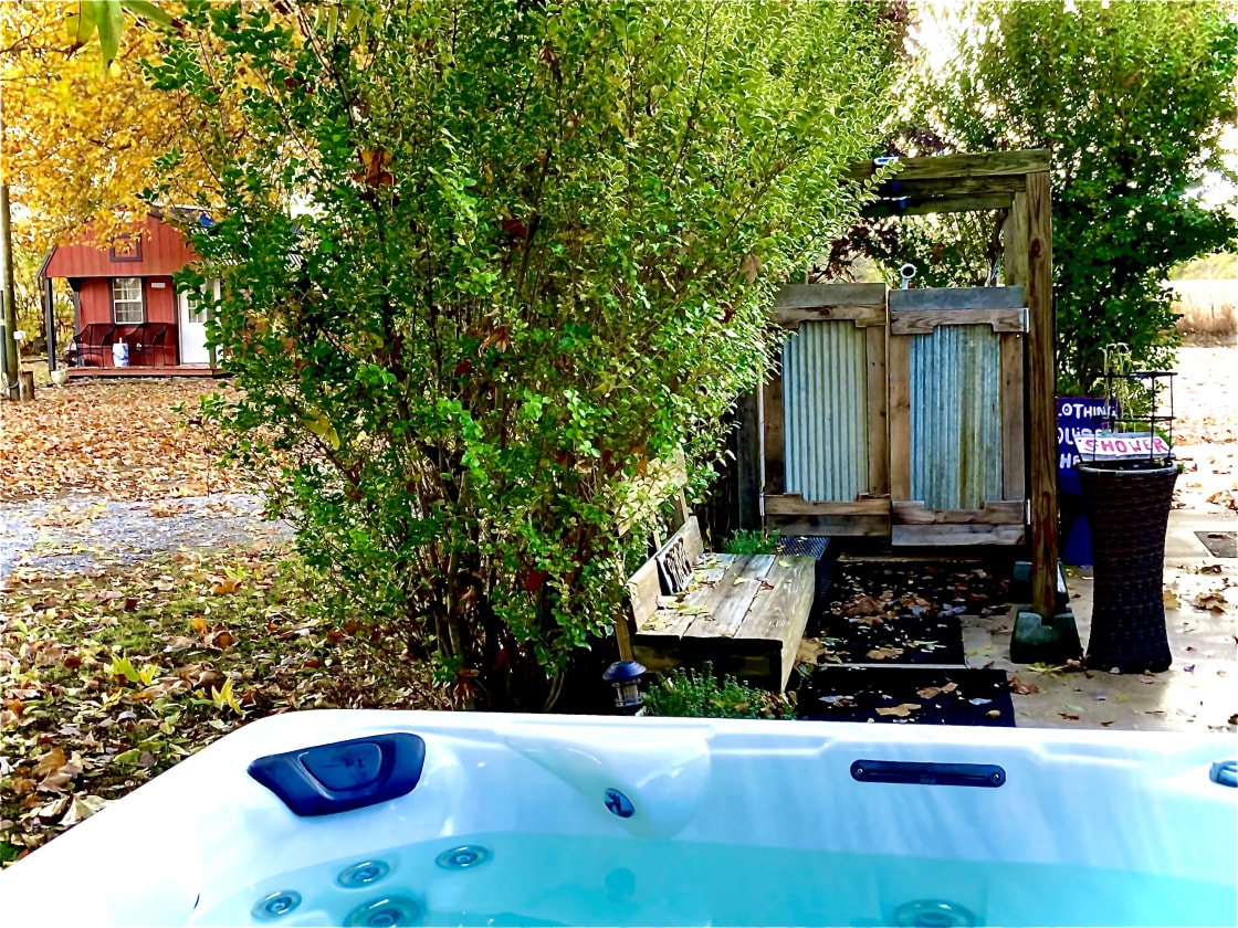 The hot tub and shower are next to the RV site. See the Cozy Cottage in the background