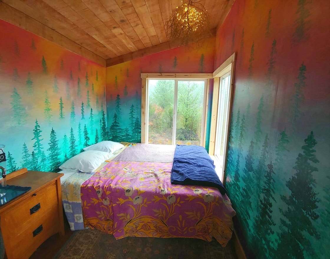 Inside the cabin with a cozy king sized bed located perfectly so you can see the view while relaxing!