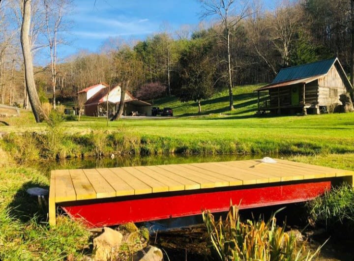 The bridge is a great place to see and catch the crayfish, salamanders, frogs and more.  Great place to hang out and listen to the water. 

Taken from the peninsula sitting area. RV spot is between the cabin and main house. 