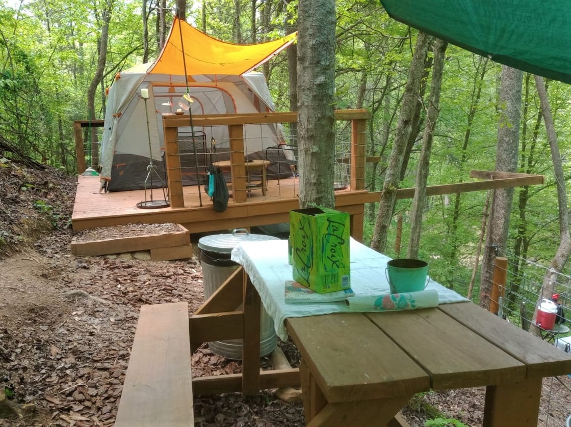  The first level of the Happy Hillside includes a deck, a small picnic table, and the two hammocks (included). Below this level is the outhouse, and additional seating. The tent in the photo belongs to a guest. It is not included. We have a smaller tent you can rent as an extra.
