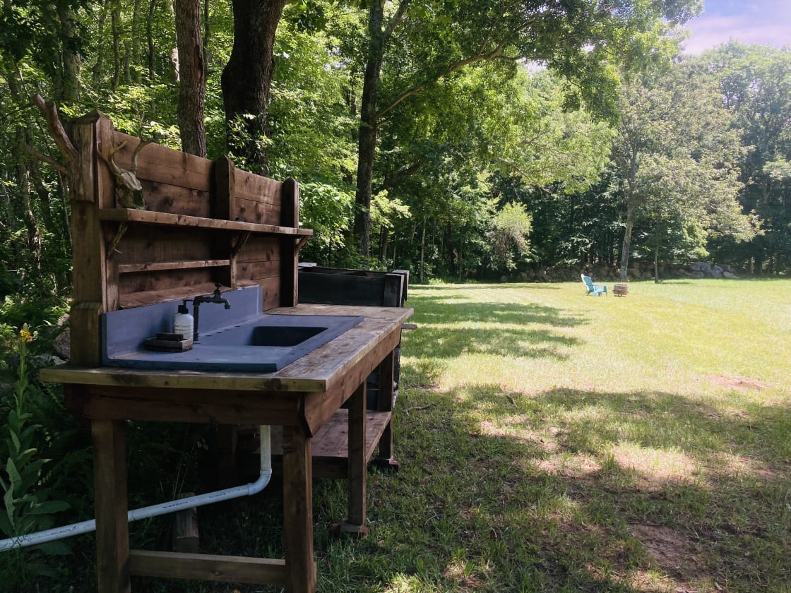 The sink station is available for your use for washing your hands and dishes. Photo taken at midday shows that the edges of the field still have shade 