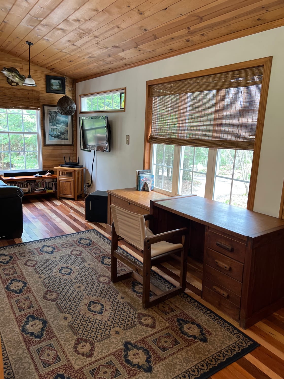 Open area of the Fern House showing desk, blanket chest, TV and sleeper couch