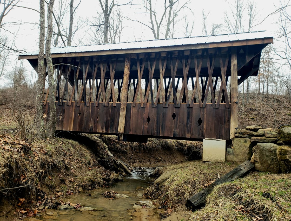 The historic restored covered bridge over the creek that brings you from the parking area to the large, shared pond and camping area.