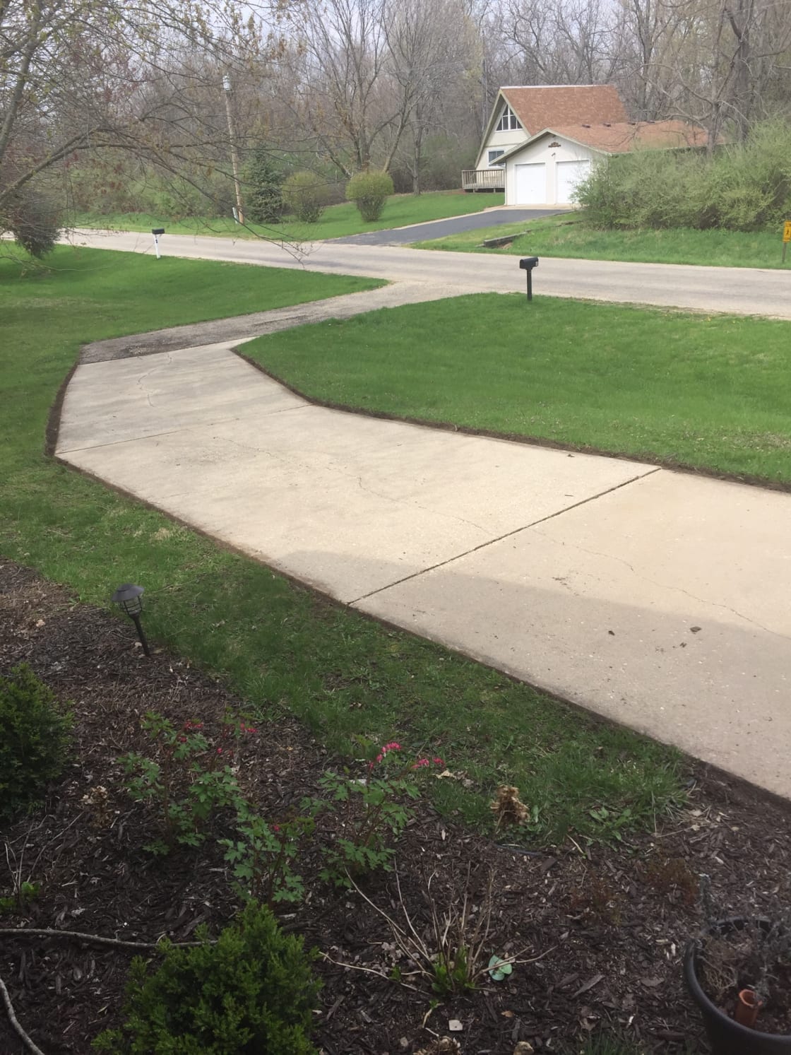 Sweeping concrete driveway runs in front of home for extra cars