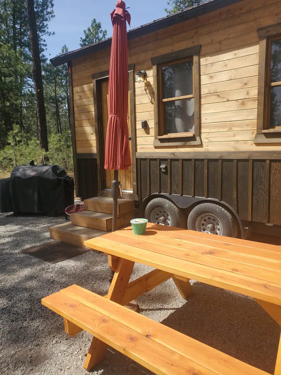 Outdoor picnic table which now has a automatic awning attached to tiny home to provide shade when not windy