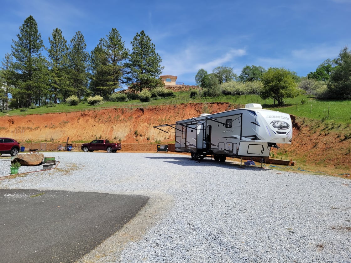 RV site can accommodate large RVs. Pictured is a 43' RV with canopies and pop out. Full hookups available. 