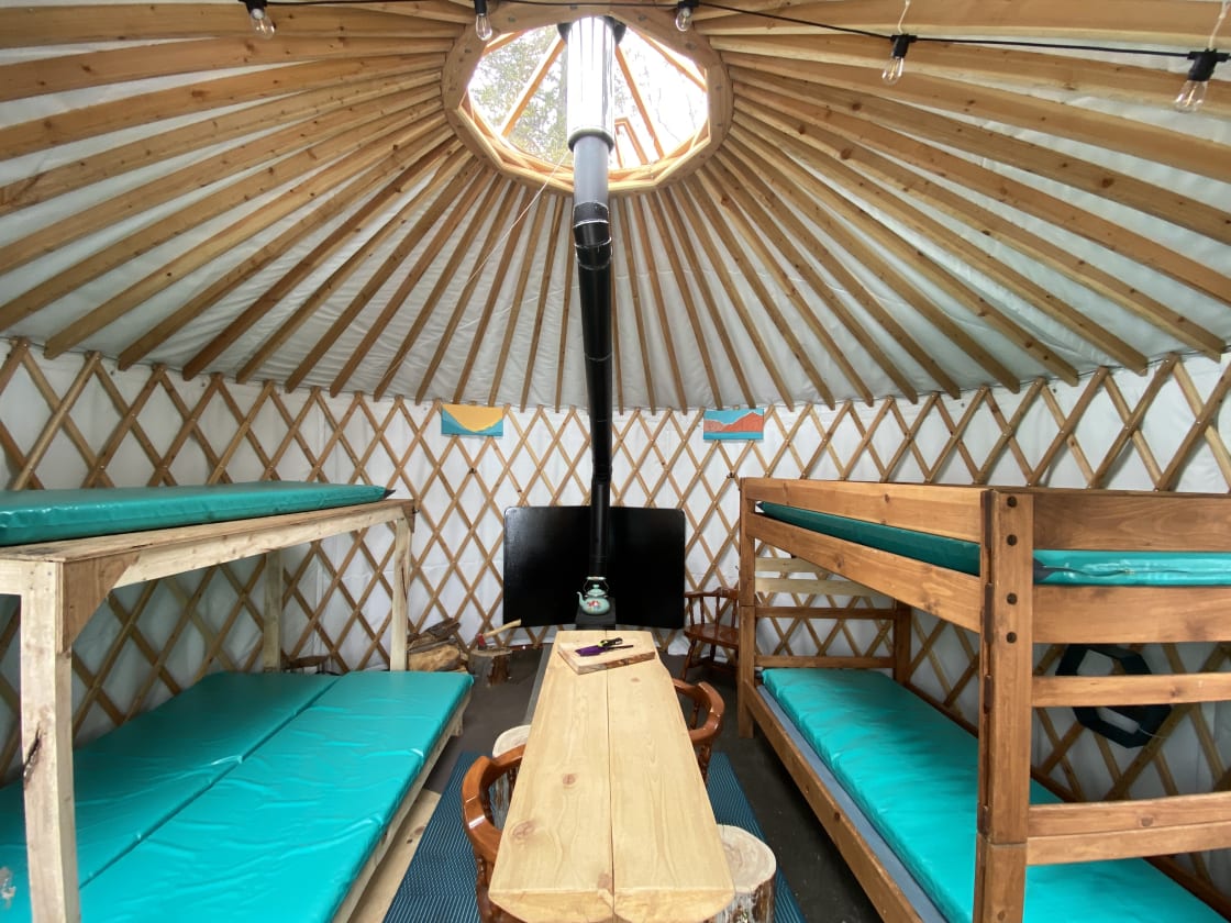Cushy camp mattresses, a sturdy spruce table and a wood stove to keep you cozy and warm.