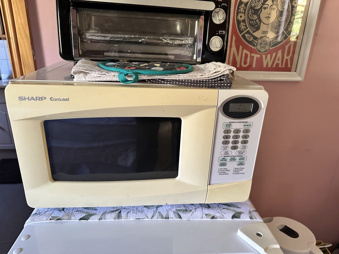 Microwave and dishes etc for cooking and toaster oven on top. 