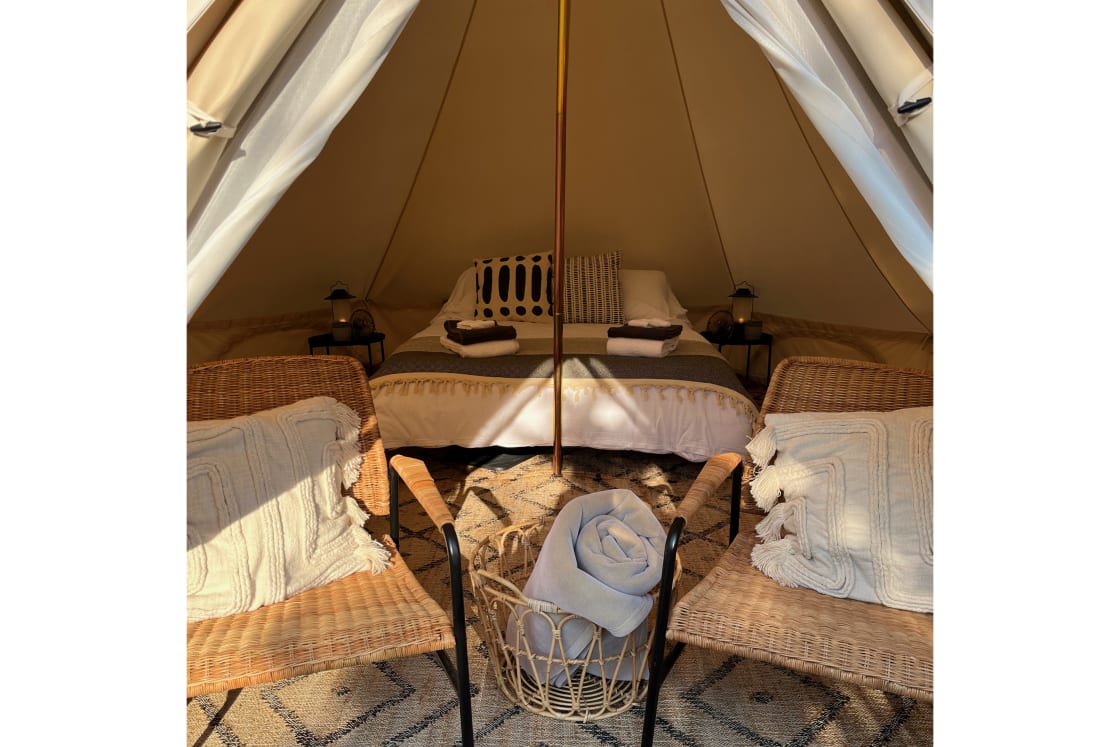 Among other things, each canvas tent includes natural fibre rugs, a queen bed with a plush memory foam mattress, hotel quality linens, bedside fans, battery powered lanterns, a power bank for recharging devices, and two indoor club chairs ✨⛺️