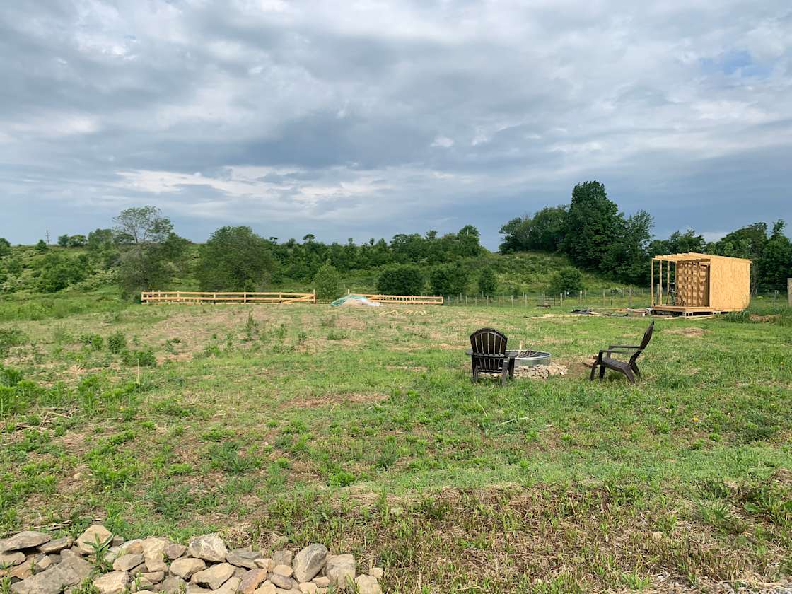 Dirt lot with fire pit and chairs
