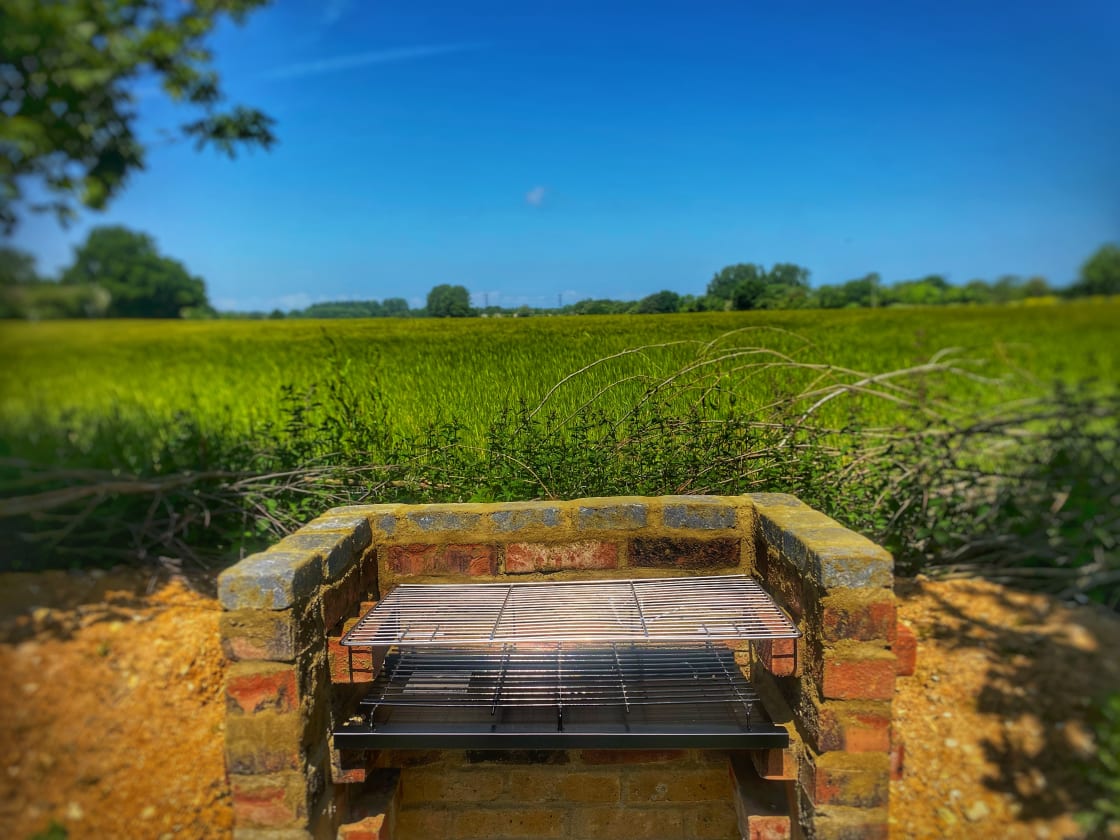 Savor the delights of outdoor dining with our bow top caravan's private brick BBQ, where you can grill your favorite meals while enjoying the Landscape views, creating lasting memories.