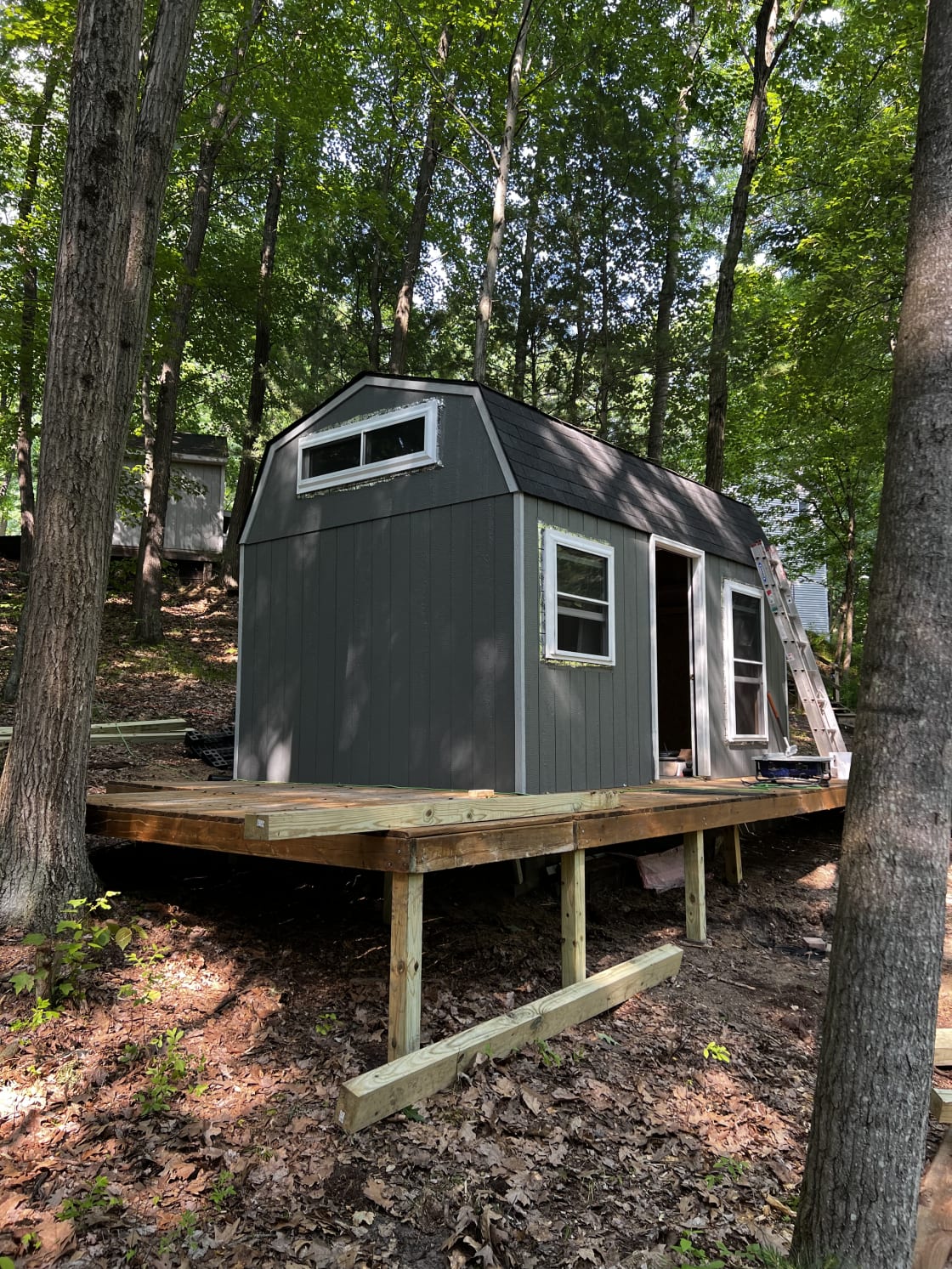 The 3-sided deck includes a grill and seating area. The outdoor shower stands in the rear of the cabin. It features a wall-surround open to sky