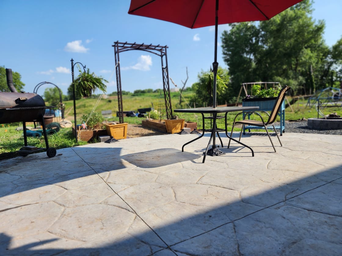 Last summer shadows on the guest patio, Charcoal grill, fire pit with grill grate and dinning tables and chairs for alfresco dining