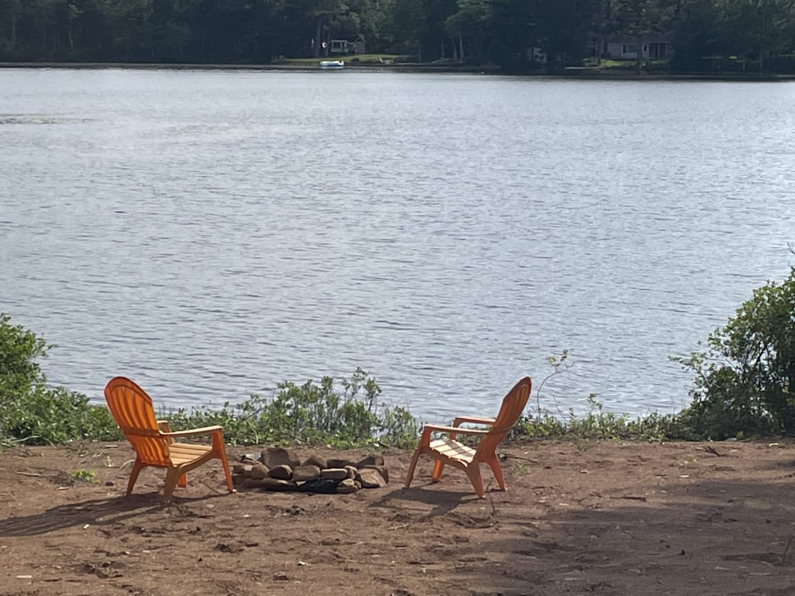 Adirondack chairs and spot for campfire right at the waters edge
