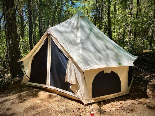 Our 13ft Bell Tent tucked away from the rest of the campground with personal outhouse, listed as the "Giggle Getaway"
