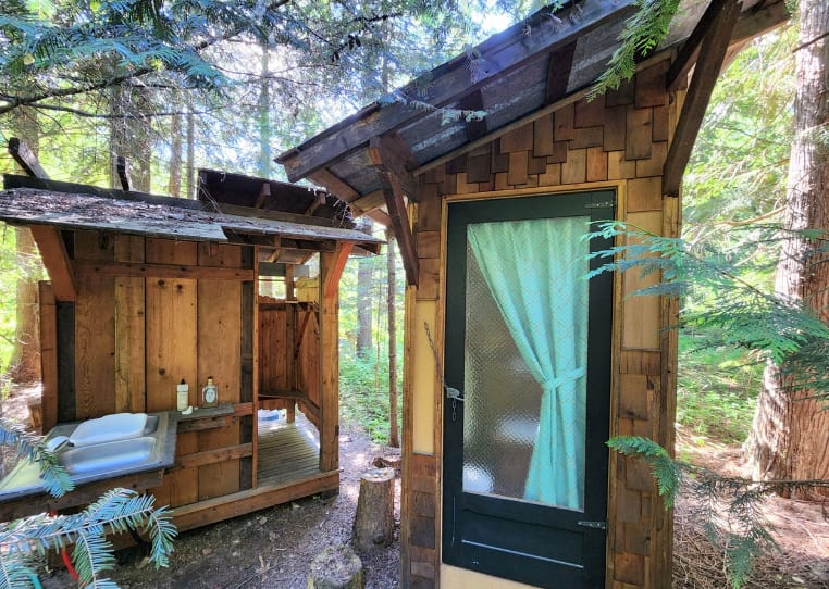 Outdoor shower (left) and outhouse (right) with incinerating toilet. 