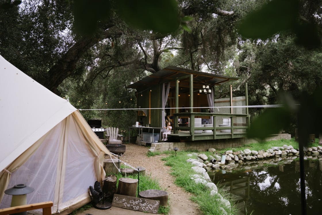 view of the glampsite with the bell tent, firepit, outdoor kitchen and living room 