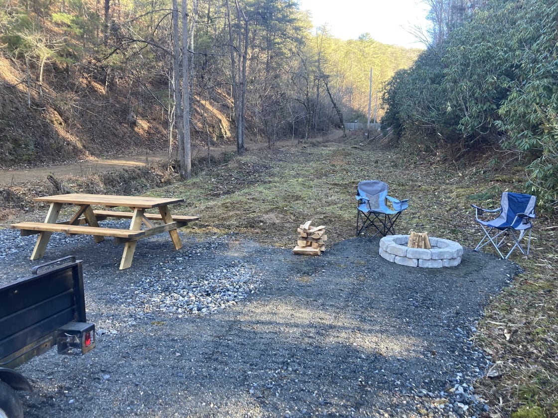 Fire Pit and Picnic Table.  A small creek runs between the site and the neighbor's secondary entrance.